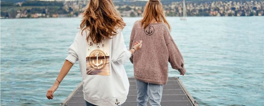 Deux femmes de dos portant des vêtements floqués d'un logo ancre
