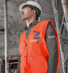 Orange hi-vis safety vest printed with a logo on a construction site