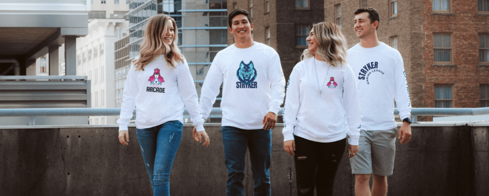 White long-sleeve tops printed with Arcade and Stryker logos, worn by four people